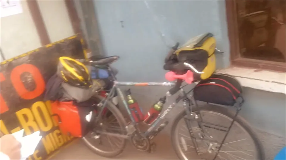A loaded bike leaning in a doorway at the border.