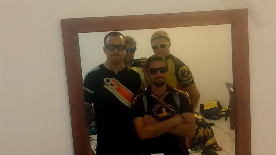 Three riders in cycling jerseys pose for a mirror selfie before a night out.
