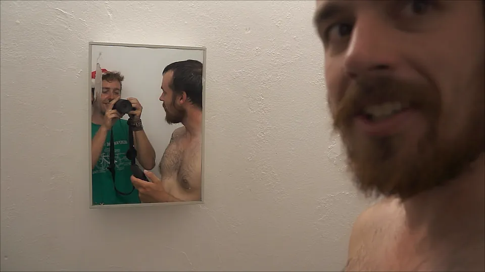 A rider shows off his Christmas moustache in a hostel mirror.