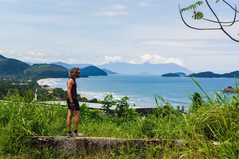 A rider sits on a wall above a bay full of green islands.
