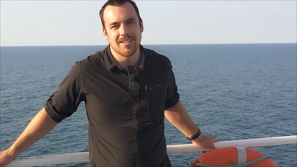 A rider on the deck of the ferry with the Sea of Cortez behind him.