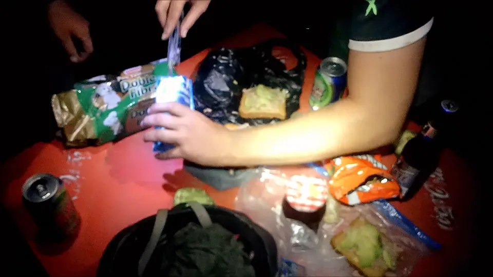 Dinner spread out on a red tablecloth: snacks, soda bottles and a little tequila.