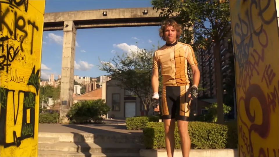 Boydy in his gold cycling jersey, standing under a stone arch in Cartagena.