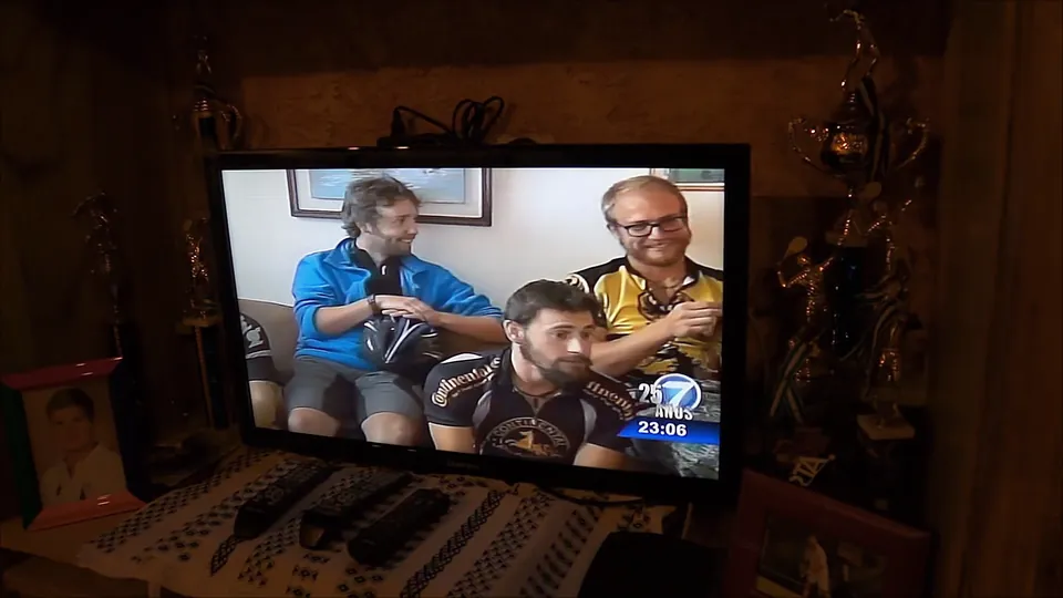 A television screen showing the riders being interviewed on the Guatemalan news.
